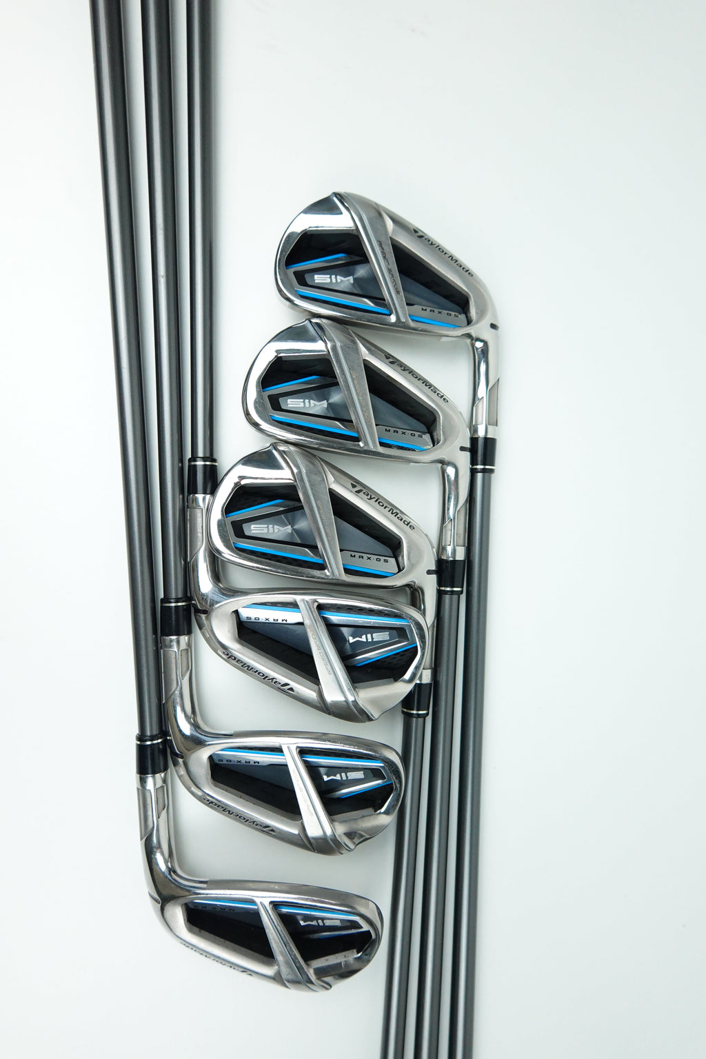 Five golf iron clubs arranged in descending size order on a clean white background, featuring a polished silver metal finish with black and blue accents on the clubheads.