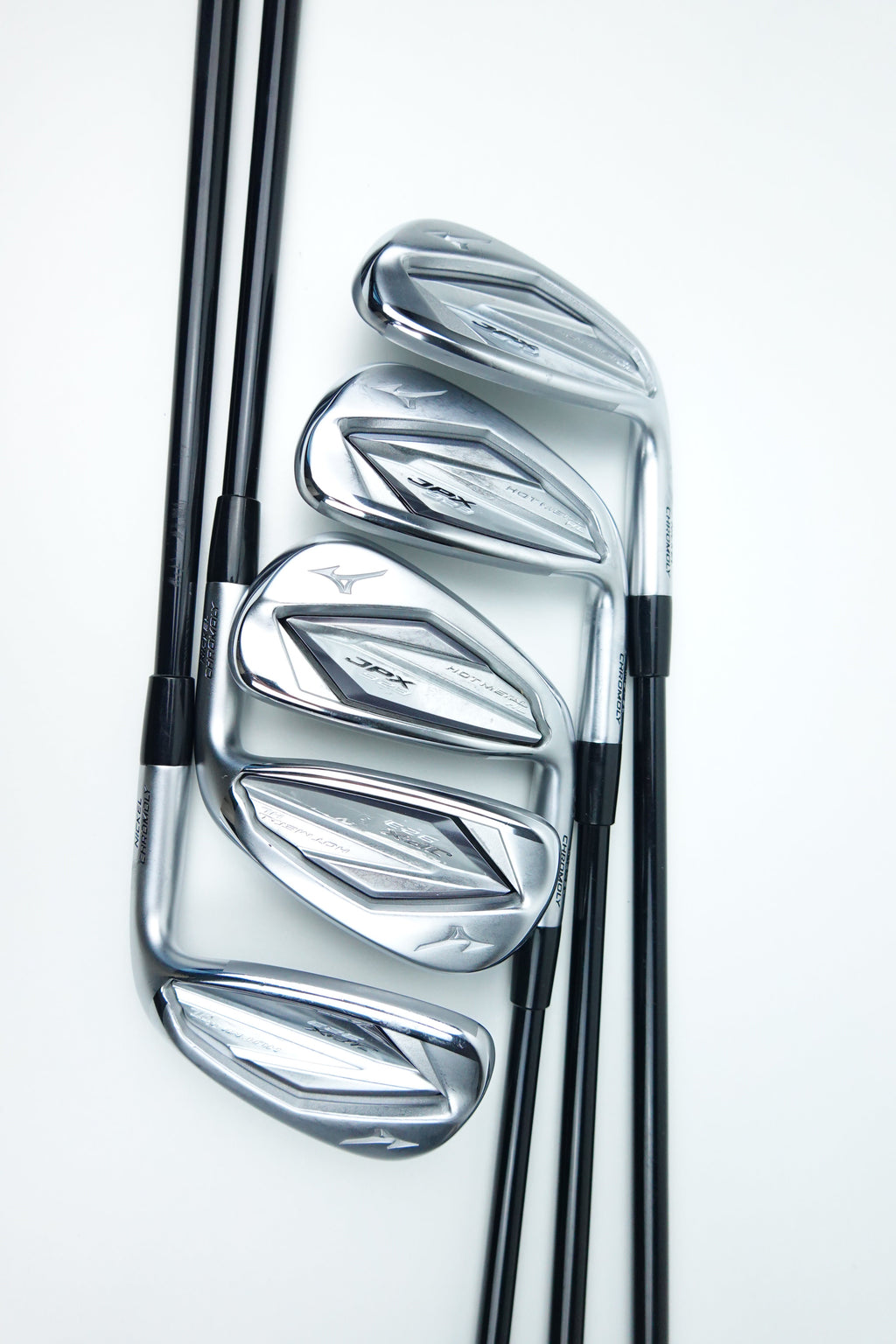 Four golf iron clubs with polished silver metal heads and black shafts, arranged diagonally on a clean white background.