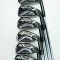 Six TaylorMade Axiom golf iron clubs arranged in a diagonal row on a clean white background.