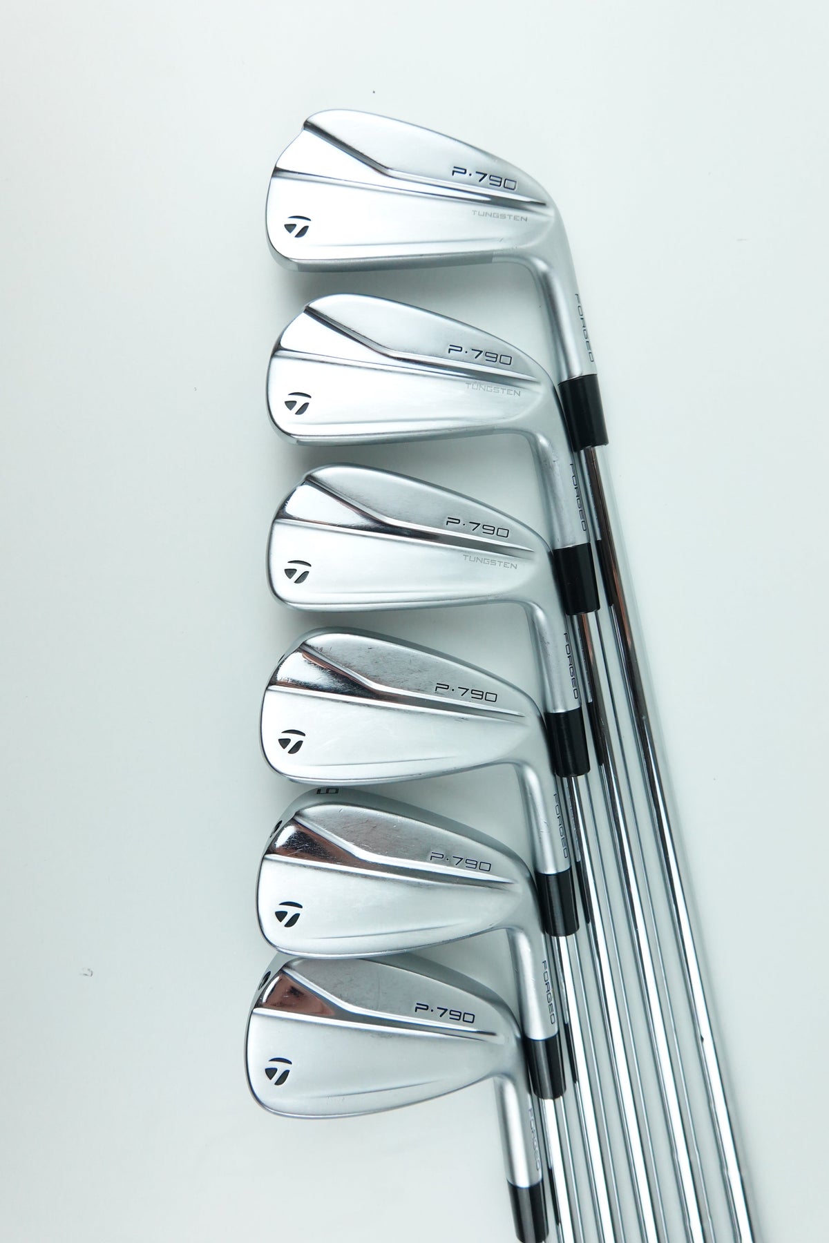 Six TaylorMade golf iron clubs arranged in a fan shape on a clean white background.