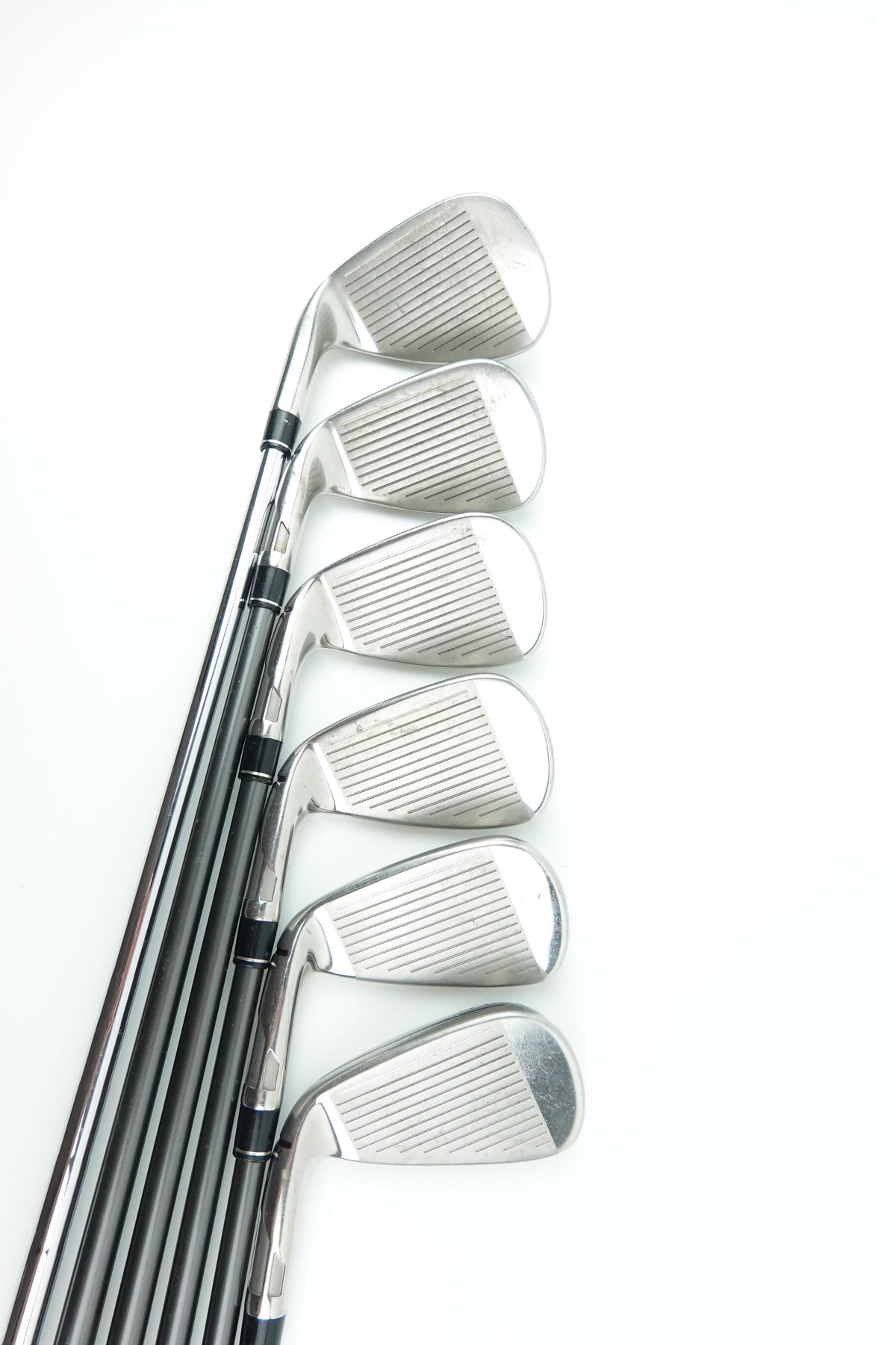 A set of seven golf iron clubs arranged in a fan shape on a plain white background.